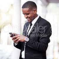 Hes a maker of big calls. a handsome young businessman checking his messages during his morning commute into work.
