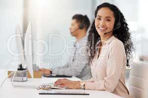 An agents mission is to provide the highest quality support to customers. Portrait of a young call centre agent working on a computer in an office.