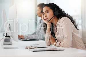 Stuck in a rut. a young call centre agent looking stressed out while working on a computer in an office.