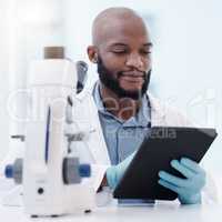 Science is organized knowledge. Shot ofa a young man using a tablet in a laboratory.