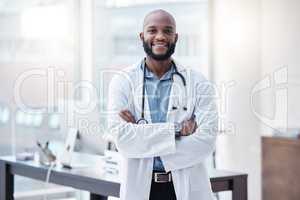 Science is the tree of wisdom. a young doctor standing alone with his arms folded in a lab.