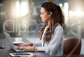 Taking charge of the business day. a young businesswoman using her laptop at work.
