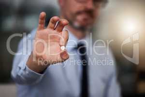Quick and easy pain relief. an unrecognizable businessman holding a painkiller in his hand while standing in a modern office.