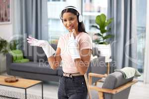 Time to clean. an attractive young woman listening to music while cleaning her home.