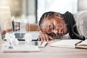 When work doesnt feel like the dream it used to be. a young businesswoman sleeping at her desk in a modern office.