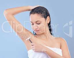 Did you know that shaving your armpits results in less sweating. a young woman using a disposable razor to shave her underarms.