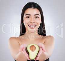 Avocados are filled with natural oils that moisturise your skin. Studio portrait of an attractive young woman posing with an avocado against a grey background.