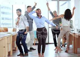 Dance break, anyone. a group of businesspeople dancing in an office at work.