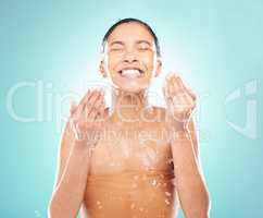 She enjoys pampering herself. a young woman doing her daily skincare routine against a blue background.