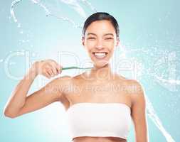 Practice excellent oral hygiene. a young woman brushing her teeth against a studio background.