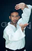 Its all about technique. Cropped portrait of a handsome young male martial artist practicing karate in studio against a dark background.