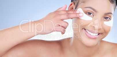 So silky. Studio portrait of an attractive young woman wearing an under eye patch against a blue background.