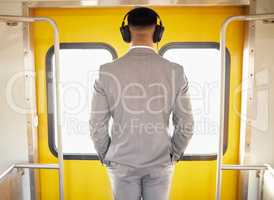Another door of opportunity will open for him. Rearview shot of a young businessman wearing headphones while standing at the doorway of a train during his commute.