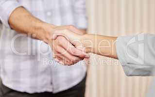 Looks like a deal. two unrecognizable businesspeople shaking hands while standing in an office.