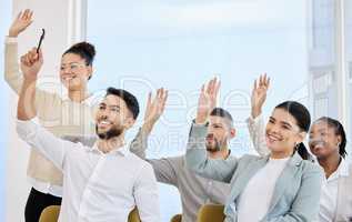 Looks like they have questions. a young and diverse group of businesspeople raising their hands during a seminar in the conference room.