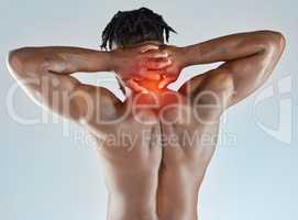 Tough but also fragile. Studio shot of a muscular young man experiencing discomfort in his neck.
