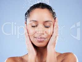 Embrace the present moment. a young woman taking a shower against a blue background.