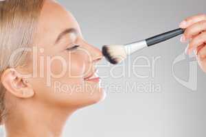 There is no instant miracle cure. an attractive young woman using a makeup brush against a studio background.