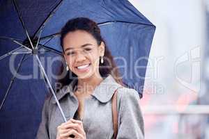 Rainy weather is her favourite. a young businesswoman carrying an umbrella in the rain.