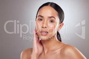 Take your time to bloom. Studio portrait of a beautiful young woman posing against a grey background.