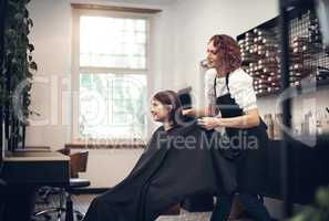 Theres a special bond between a stylist and her regulars. a beautiful young woman getting her hair done at the salon.