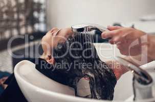 Rinsing makes all the difference. a young girl getting her hair washed at the salon.