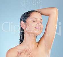 Wash away the worries of yesterday. Studio shot of an attractive young woman taking a shower against a blue background.