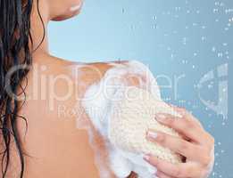 Dont hate, exfoliate. Studio shot of an unrecognisable woman taking a shower against a blue background.