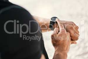 Set goals then crush them. an unrecognizable man checking his watch while out for a workout.