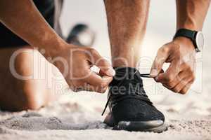 Nothing can stop you now. an unrecognizable man tying his shoelaces while out for a workout.