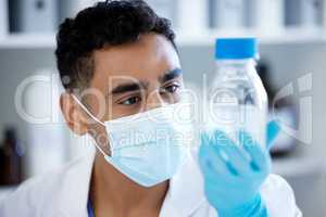 Working towards a new discovery. a young man analysing a sample in a lab.