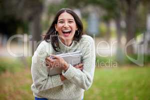 Study hard, laugh a lot. Portrait of a young woman carrying her schoolbooks outside at college.