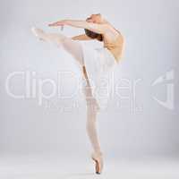 Youre not truly free until you dance. Studio shot of a young woman performing a ballet recital against a grey background.