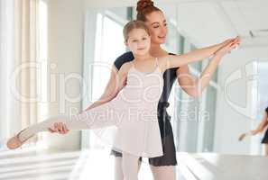 Ballet is ultimately a logical technique. a little girl practicing ballet with her teacher in a dance studio.