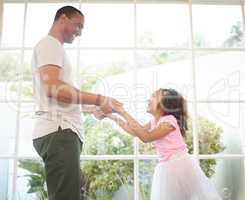 Dad, dance with me. a handsome young man bonding with his daughter at home.