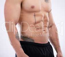 Building muscle is about hard work. a male athlete posing against a grey studio background.