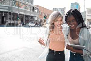 Laughing, happy and trendy students walking together in city after study class with a tablet downtown. Stylish, cool and funky women and young friends bonding, embracing and hugging on a town street