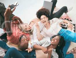 Excited, creative team using a phone for a selfie while relaxing, enjoying work and having fun. Diverse group of business colleagues showing teamwork, unity and togetherness from above