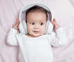 Stimulating and developing his auditory senses. High angle shot of an adorable baby wearing headphones at home.