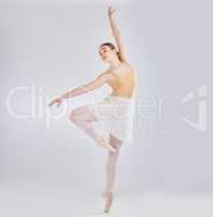 Feel with your feet. Studio shot of a young woman performing a ballet recital against a grey background.