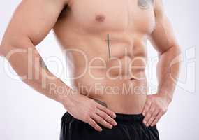 Can you count these abs. a male athlete posing against a grey studio background.