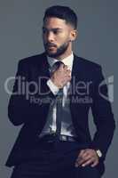 He knows everything about style. Studio shot of a young man posing against a grey background.