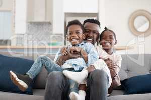 Bonding with dad. Cropped portrait of an affectionate young family of three relaxing in the living room at home.