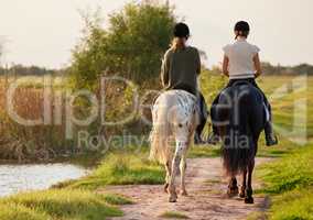 Words are as beautiful as wild horses. two unrecognizable women riding their horses outside on a field.