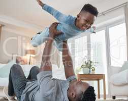 Defying the laws of gravity. a young father lying on the the living room floor and bonding with his son at home.