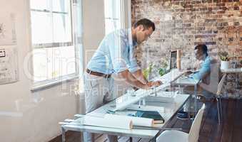 Working, writing and thinking building designer planning infrastructure on blueprint paper in an office. Serious, confident and ambitious architect designing residential, office and city development