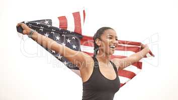 Feeling the wind in my wings. a young female athlete holding the american flag.