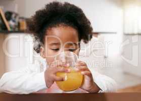 Mom finally let me have juice. a little girl drinking a glass of juice.