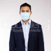 Follow all health protocols to keep everyone safe. Studio portrait of a young businessman wearing a face mask against a white background.