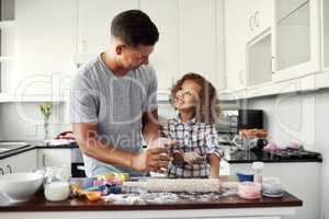 My dad is my hero. a sweet little girl baking with her father at home in the kitchen.